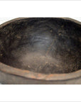 Close-up of a brown antique hand-carved wooden offering bowl with rustic interior and irregular organic rim.