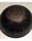 Brown hand-carved wooden offering bowl with a rough surface on a plain white background, close-up view.