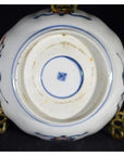 Close-up of ceramic bowl base with blue and red floral designs and a blue square mark in the center.
