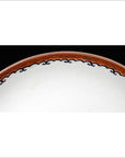 Close-up of antique hand-painted Asian plate with red and black rim, partial view on a black background.
