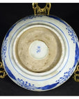Close-up of the underside of an antique hand painted Chinese porcelain bowl with blue mark, on brass stand.