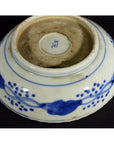 Blue porcelain Chinese bowl with hand-painted blue floral designs and a maker's mark on its unglazed base.