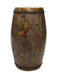 Close-up of a hand-painted brown ceramic Chinese antique drum with colorful butterfly designs and a beaded rim.