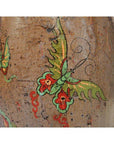 Close-up of brown ceramic antique Chinese drum with hand painted butterflies and swirling designs.