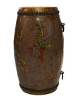 Brown hand-painted antique Chinese drum with green and red designs, metal studs along edges, close-up view.