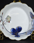 Set of 4 blue and gold hand painted Japanese Imari porcelain bowls with scalloped edges, close-up on white background.