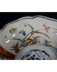 Close-up of a multicolored porcelain Japanese Imari bowl with hand-painted floral and geometric patterns.