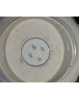 Close-up of blue and white porcelain bowl bottom with hand painted blue characters and circular blue border.