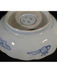 Blue and white porcelain bowl with hand painted designs and unglazed base ring, shown on a plain background.