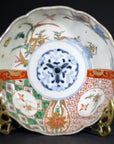 Close-up of an antique Japanese Imari porcelain bowl with vibrant hand-painted patterns on a brass stand.