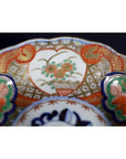 Close-up of red, green, blue, and gold floral hand painted Japanese Imari porcelain bowl.