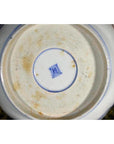 Close-up of blue and brown base on porcelain bowl with square mark and patina.
