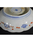 Blue and red porcelain bowl upside down on a dark background.