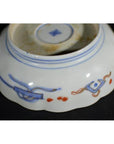 White porcelain bowl with blue and red floral designs along the rim, hand painted, antique style.