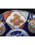 Close-up of a blue, red, and gold hand painted Japanese Imari porcelain bowl with intricate patterns.