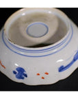 Blue and red porcelain bowl, hand painted, upside down on black surface.