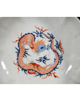Set of four antique Japanese Imari porcelain bowls with hand-painted red and blue dragons and blue flames, on table.