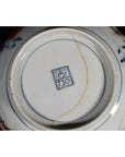 Close-up of base of antique hand-painted blue and white Japanese Imari porcelain bowl with maker’s mark and visible crack.
