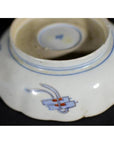 Close-up of blue and red porcelain bowl underside, hand painted, showing Japanese Imari design.