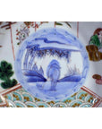 Blue and white porcelain Japanese Imari bowl with hand painted landscape, figure in hat, and vibrant patterns.