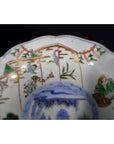 Close-up of a colorful hand painted Japanese Imari porcelain bowl with figures, birds, and foliage decoration.