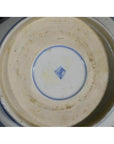 Blue and white porcelain bowl underside with blue square mark and light base staining, close-up.