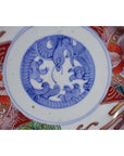 Close-up of an antique hand-painted porcelain Japanese Imari bowl with blue bird and cloud center motif.
