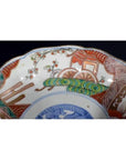 Close-up of a multicolor porcelain Japanese Imari bowl with hand painted floral patterns and intricate rim design.