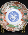 Close-up of blue, red, and green hand painted Japanese Imari porcelain bowl with serpent design.