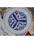 Close-up of four antique hand-painted Imari porcelain bowls with blue floral centers and multicolor decorative rims.