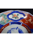 Close-up of four ceramic bowls with red, blue, and green floral rim patterns, hand-painted in antique style.