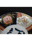 Close-up of a multicolored porcelain Japanese Imari bowl with hand-painted floral and bird patterns.