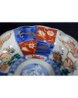 Close-up of a red, blue, and gold floral Japanese Imari porcelain bowl, antique, hand painted.