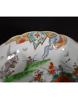 Close-up of an antique hand-painted Japanese Imari porcelain bowl with floral designs and a vibrant ornate rim.