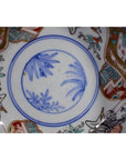 Close-up of blue and white hand painted Japanese Imari porcelain bowl with floral, bird, and geometric designs.