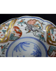 Close-up of blue, gold, red, and green hand painted Japanese Imari porcelain bowl with floral and bird designs.