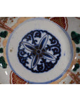 Close-up of blue and multicolored hand painted Japanese Imari porcelain bowl with floral center on white background.