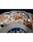 Close-up of red, green, and gold hand painted porcelain Japanese Imari bowl with antique patterns.