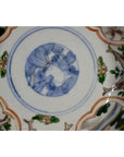 Close-up of blue, green, red, and gold hand painted patterns on antique Japanese Imari porcelain bowl.
