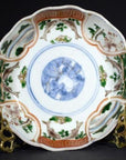 Colorful porcelain Japanese Imari bowl with hand-painted florals and bold blue circular motif, close-up.