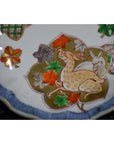 Close-up of an antique hand painted Japanese Imari porcelain bowl with a deer among colorful leaves and patterns.