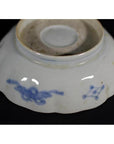 Blue and white porcelain Japanese Imari bowl, hand painted, upside down against a black background.