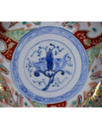 Close-up of a blue, red, gold, and green hand painted Japanese Imari porcelain bowl with floral and geometric patterns.