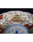 Colorful porcelain Japanese Imari bowl with hand-painted crab design on inner rim, antique style, close-up view.