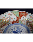 Close-up of colorful hand painted floral and geometric designs on antique Japanese Imari porcelain bowl.