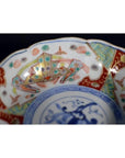 Close-up of colorful hand painted Japanese Imari porcelain bowl with geometric and intricate rim designs.
