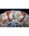White porcelain Japanese Imari bowl with vibrant hand painted floral motifs, antique, close-up view.
