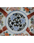 Close-up of blue, red, green, and gold hand painted Japanese Imari porcelain bowl with antique patterns.