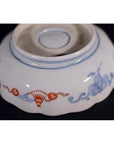 Close-up of the base of a blue and red porcelain Japanese Imari bowl with hand-painted floral patterns.