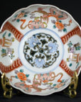 Close-up of antique Japanese Imari porcelain bowl with red, blue, green, and orange floral and geometric patterns.